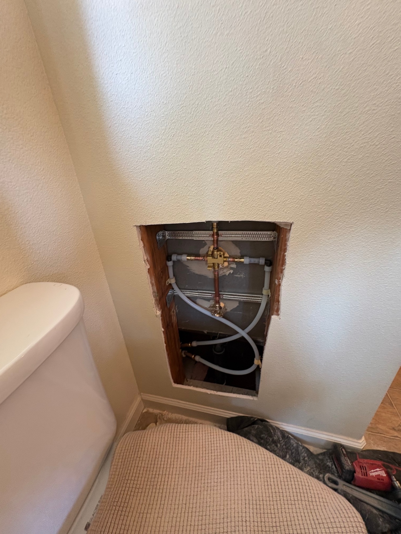 Shower thermostatic mixing valve rough-in behind bathroom wall