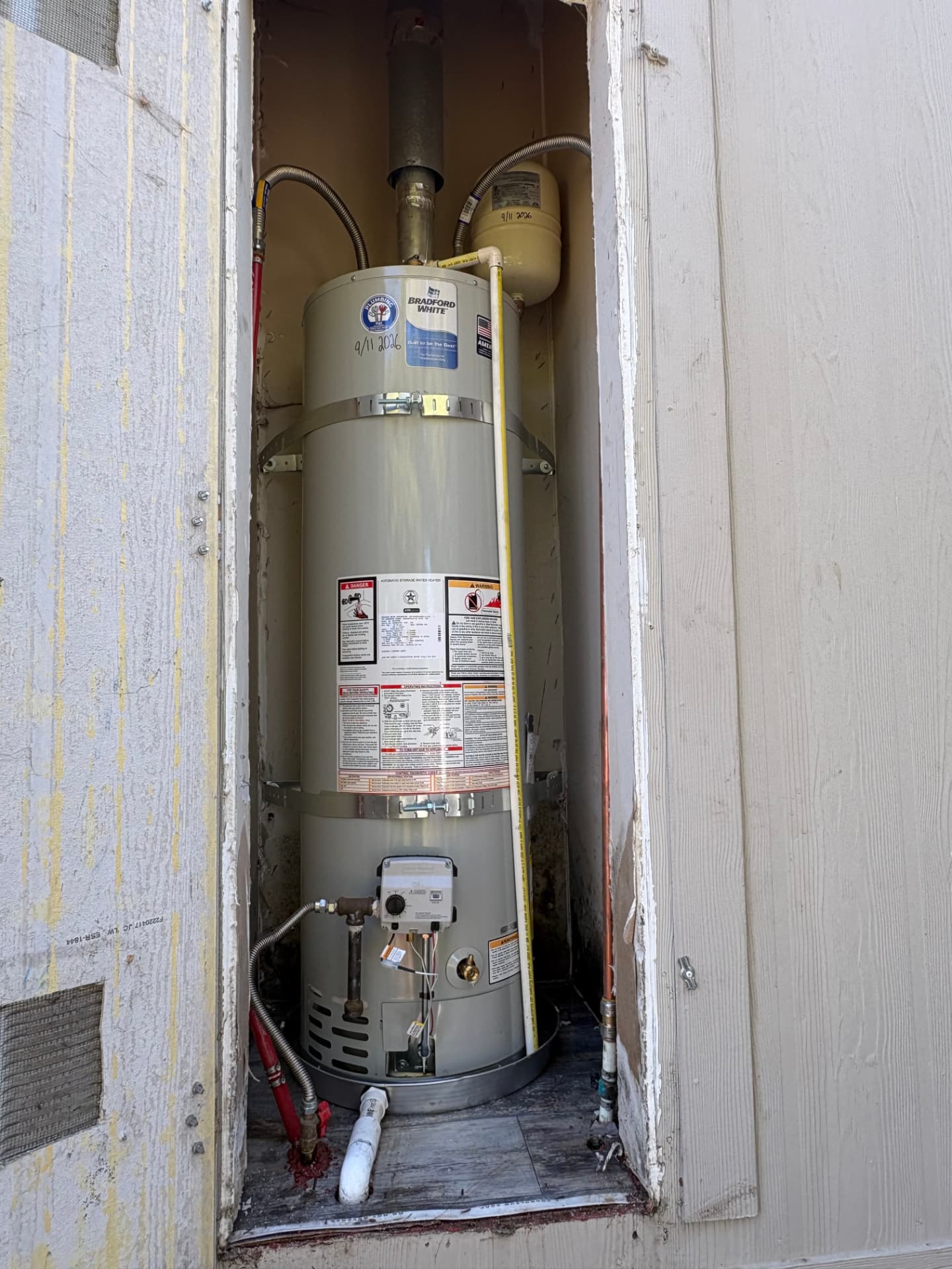 Bradford White water heater replacement in exterior closet with seismic strapping